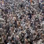 Naga Sadhus or Hindu holy men raise their arms while shouting religious hymns on the banks of the river Ganges after taking the holy dip during the third ‘Shahi Snan’ at the ongoing “Kumbh Mela” or Pitcher Festival, in Allahabad